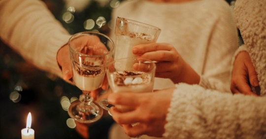 people drinking eggnog by Christmas tree