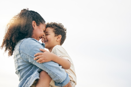 Mother hugging son and smiling